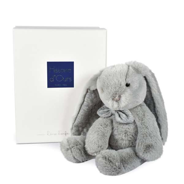 Gray plush bunny with a ribbon beside a white gift box