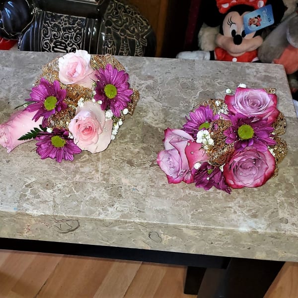 Three small rose and daisy floral arrangements on a table