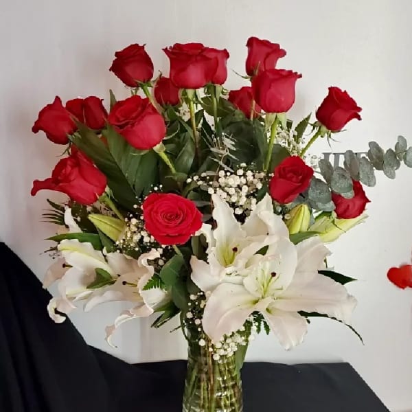 Red roses and white lilies arranged in a glass vase