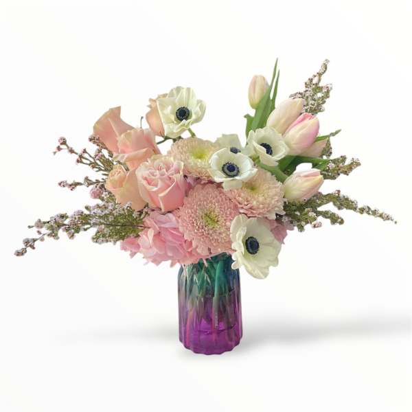 Pink and white bouquet in a purple glass vase