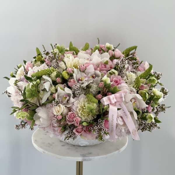Large pastel bouquet of pink and white flowers in a low vase