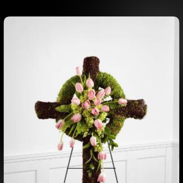 Floral cross with pink tulips and greenery on an easel