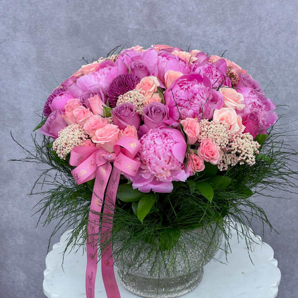 Pink floral arrangement in a glittery vase with a ribbon bow