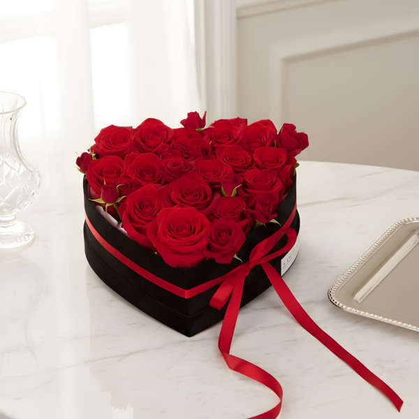 Heart-shaped box of red roses tied with a red ribbon