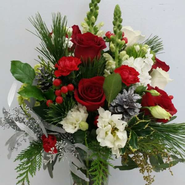 Red and white flower arrangement in a clear glass vase