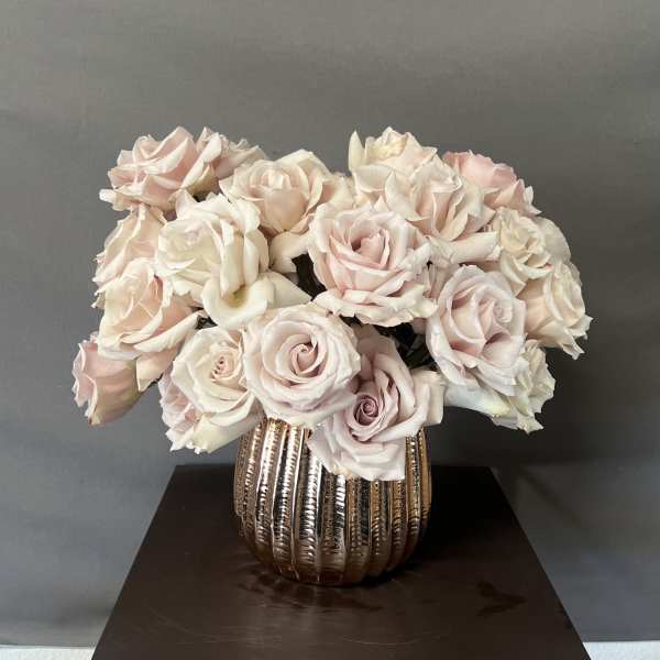 Bouquet of pale pink and white roses in a metallic vase