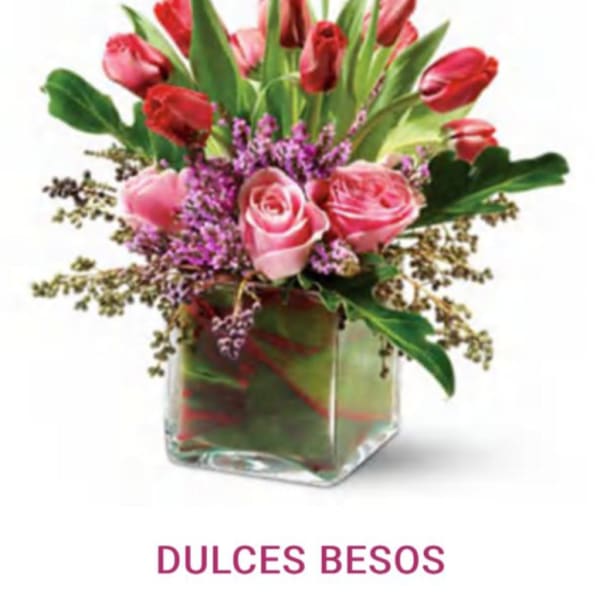 Pink roses and red tulips in a square glass vase