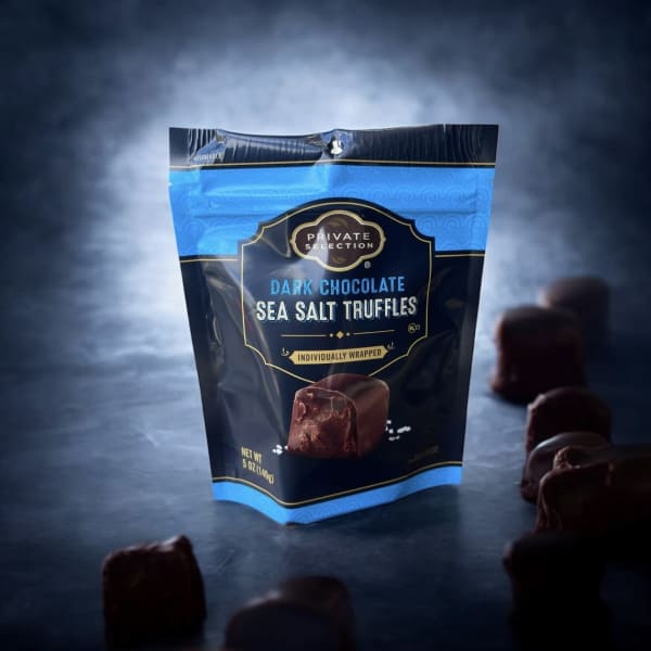 Bag of dark chocolate sea salt truffles with pieces scattered around