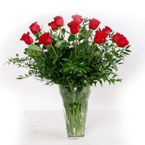 Red roses arranged in a clear glass vase