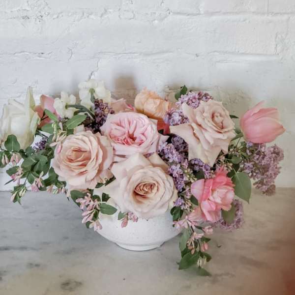 Pastel rose and tulip arrangement in a white bowl vase