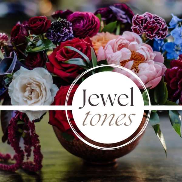 Mixed bouquet of roses, peonies, and blue flowers in a vase