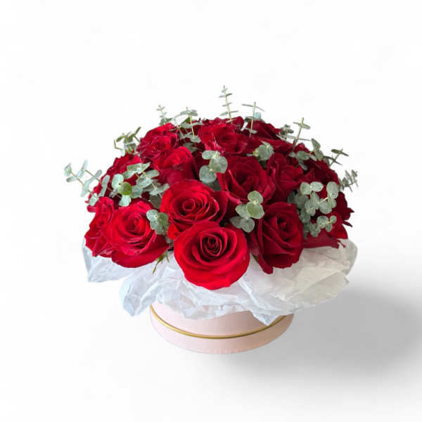 Red rose bouquet in a pink round box with white wrapping