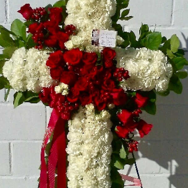 Cross-shaped floral tribute with red roses and white carnations