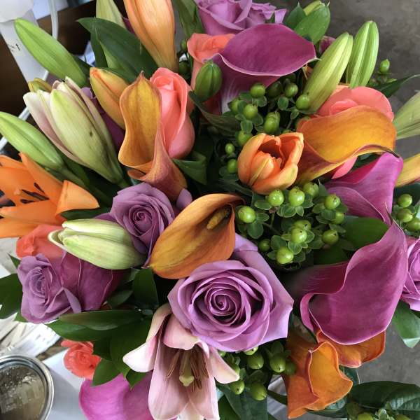 Bouquet of purple roses, orange lilies, and pink calla lilies
