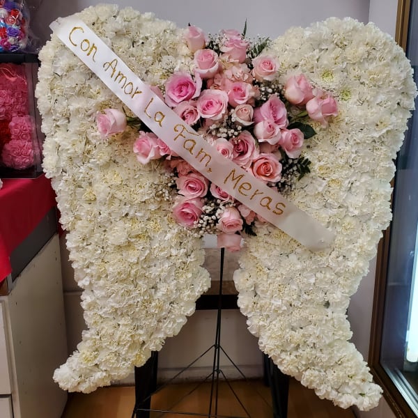 Heart-shaped white floral wreath with pink roses and a diagonal ribbon