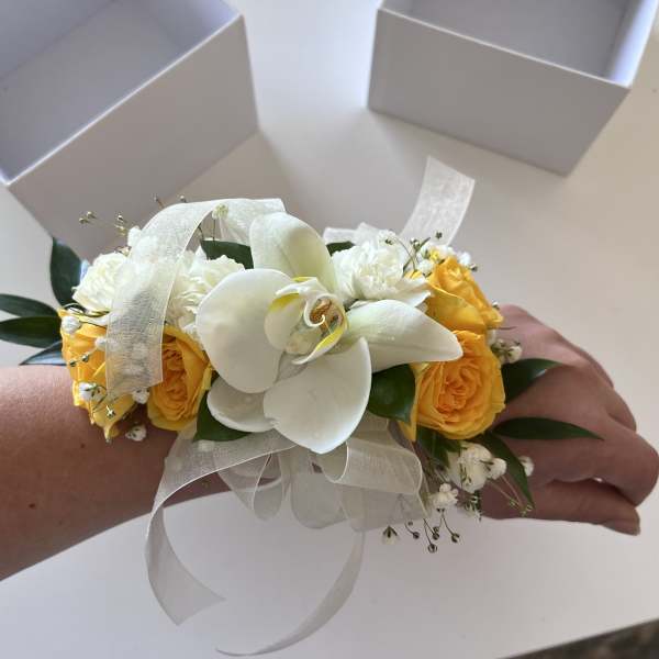 White orchid wrist corsage with yellow roses and ribbon