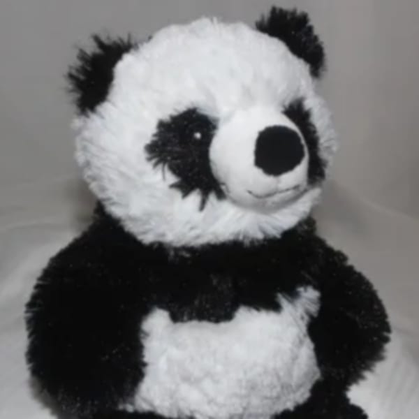 Plush panda bear sitting upright on a light background