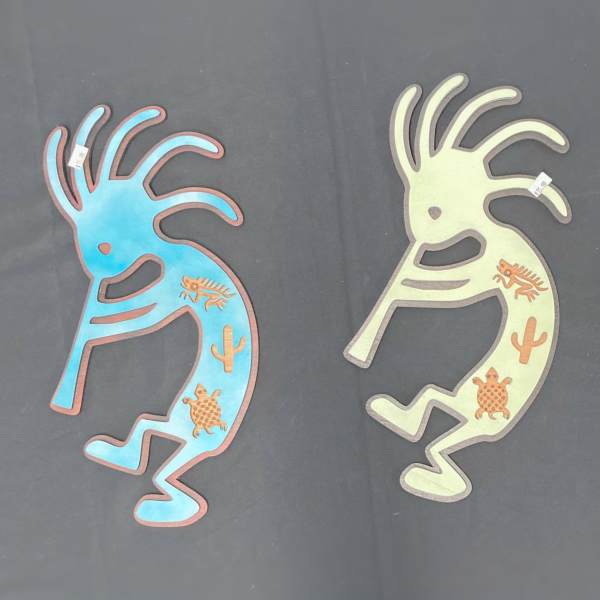 Three colorful Kokopelli-style wall decorations on a dark background