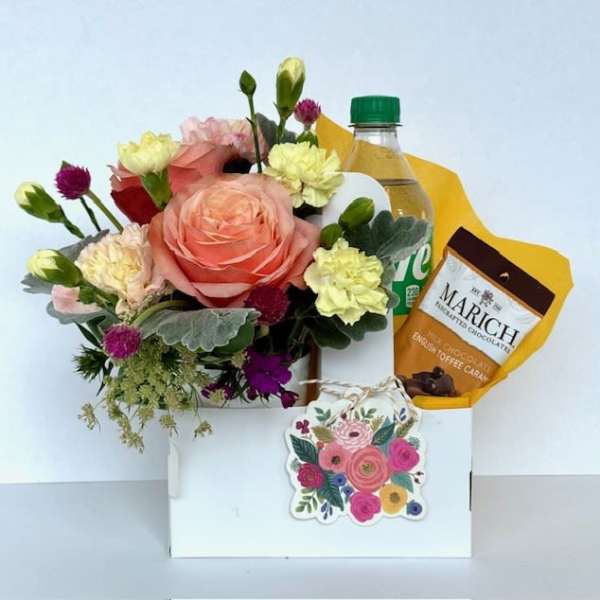 Mixed flower bouquet with chocolates and a drink in a gift box
