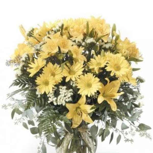 Yellow flowers arranged in a clear glass vase