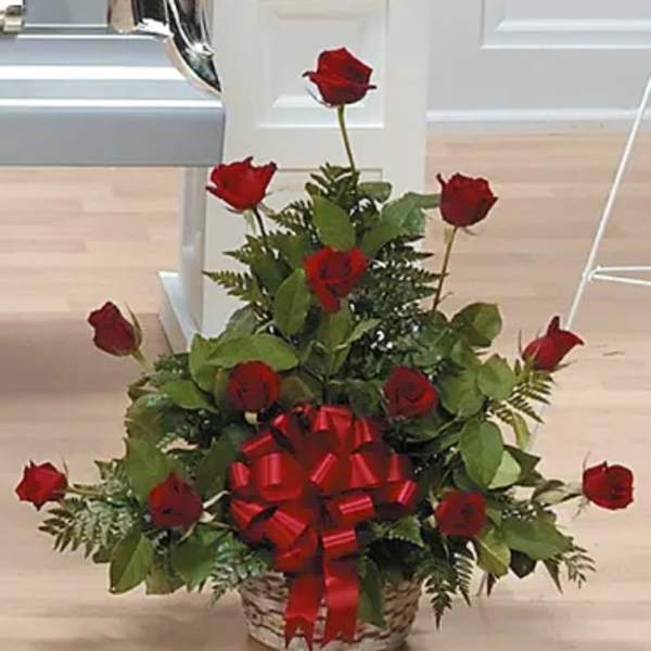Basket arrangement of red roses with a large red bow