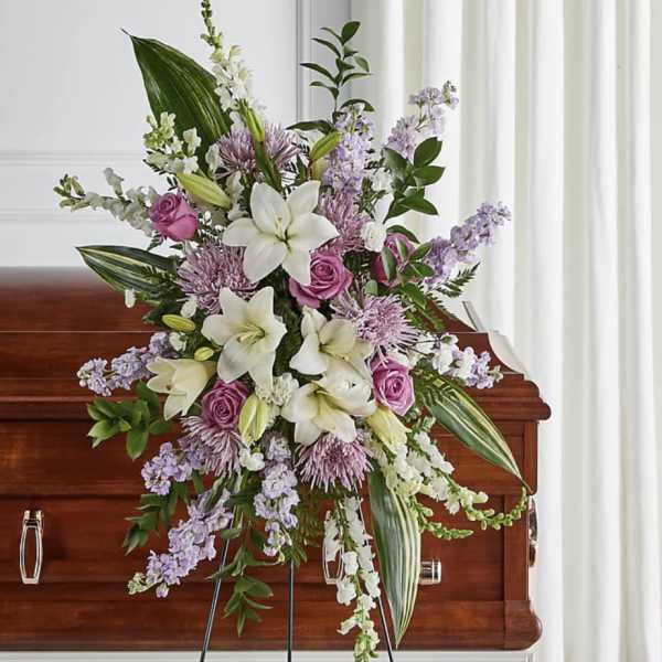 Large floral spray with white lilies and pink roses on a casket