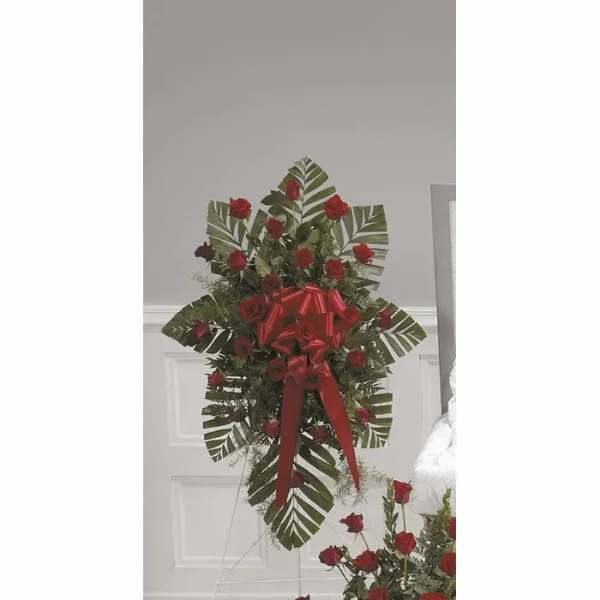 Standing spray of red roses with a red ribbon