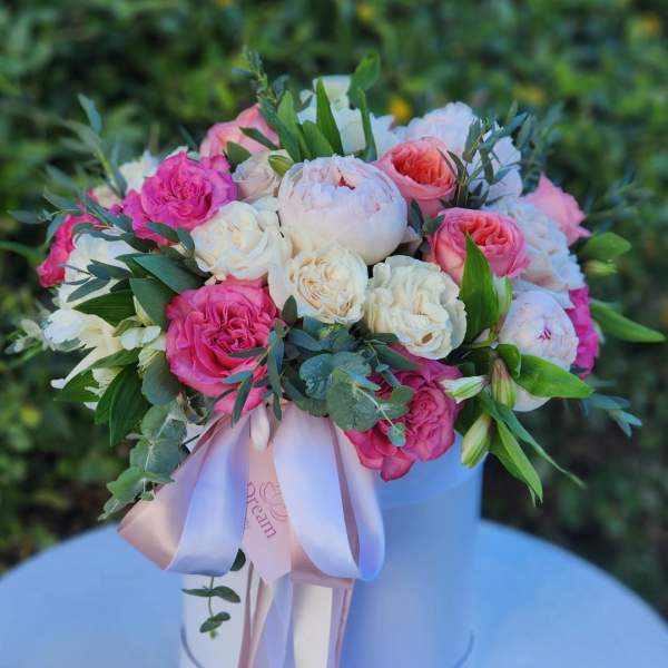 Pink and white rose bouquet in a white hat box with ribbon
