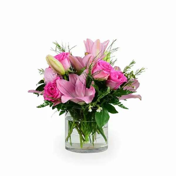 Pink lilies and roses in a clear glass vase
