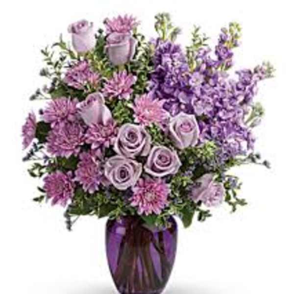 Purple and lavender bouquet in a purple glass vase
