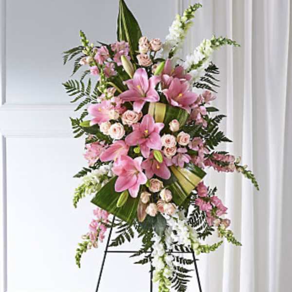 Standing floral spray with pink lilies and roses on an easel