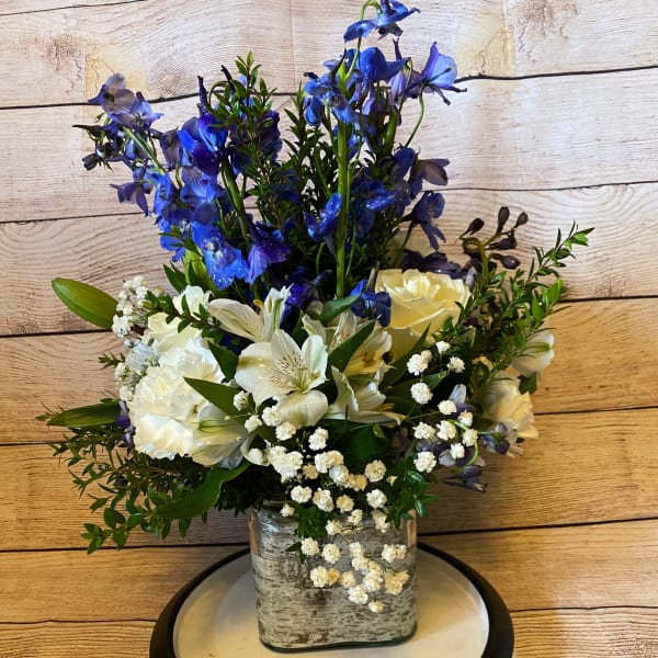 Blue and white floral arrangement in a square glass vase