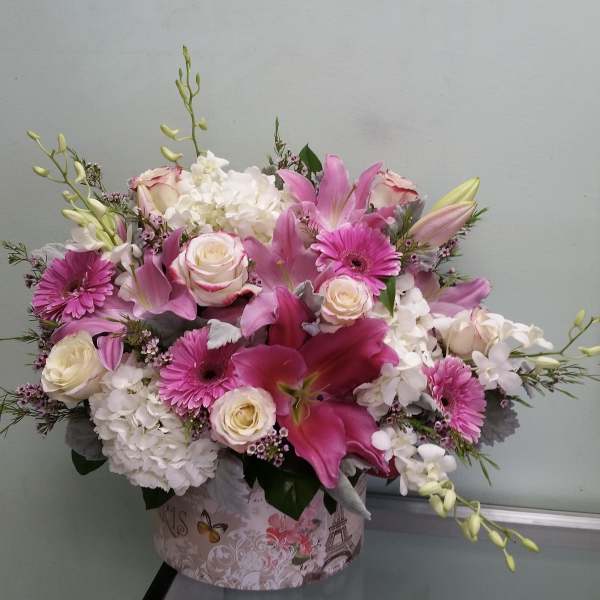 Pink and white mixed flower arrangement in a decorative box