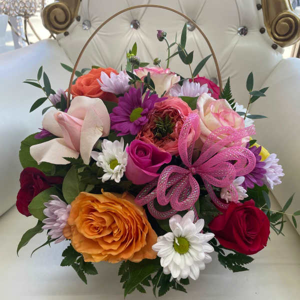 Mixed bouquet of roses and daisies with a pink ribbon bow