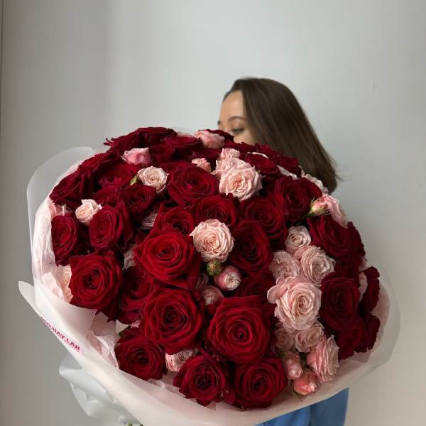 Large bouquet of red and blush roses wrapped in white paper