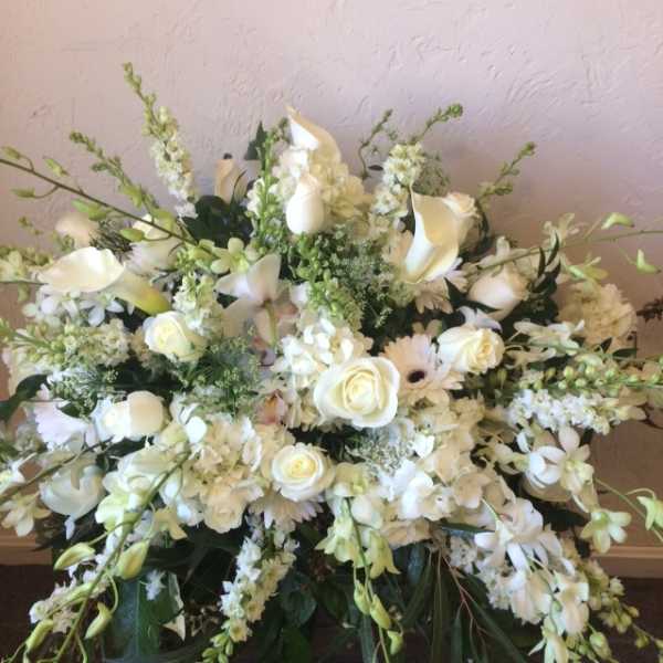 Large white floral spray with roses, calla lilies, and daisies