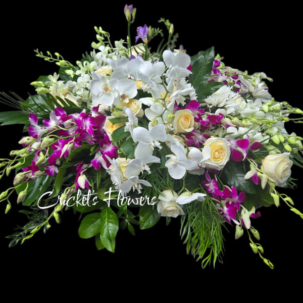 White orchids and cream roses with purple orchids in a low arrangement