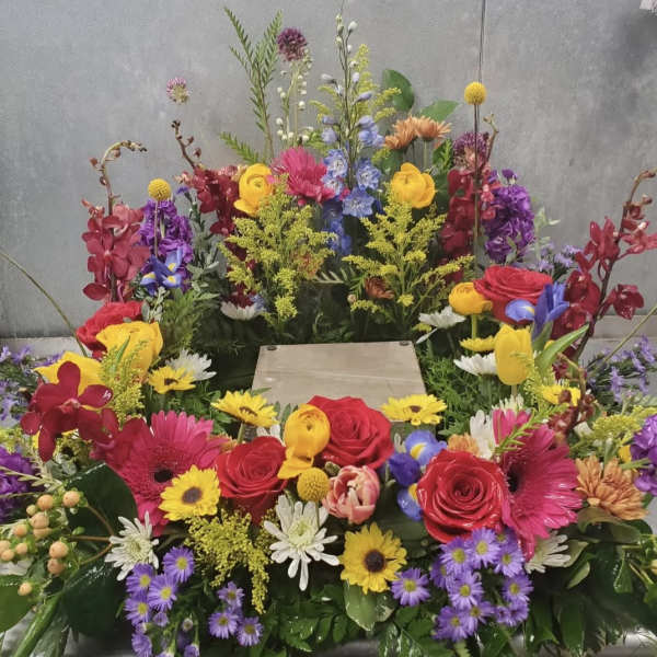 Colorful mixed flower arrangement with roses, gerbera daisies, and orchids