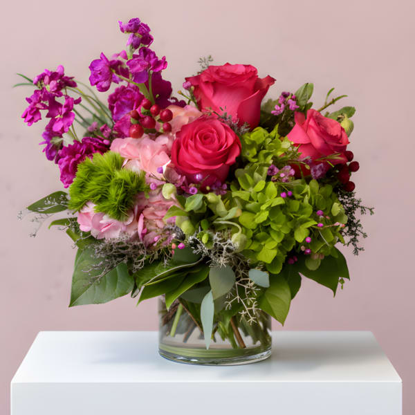 Bouquet of pink roses and purple orchids in a glass vase