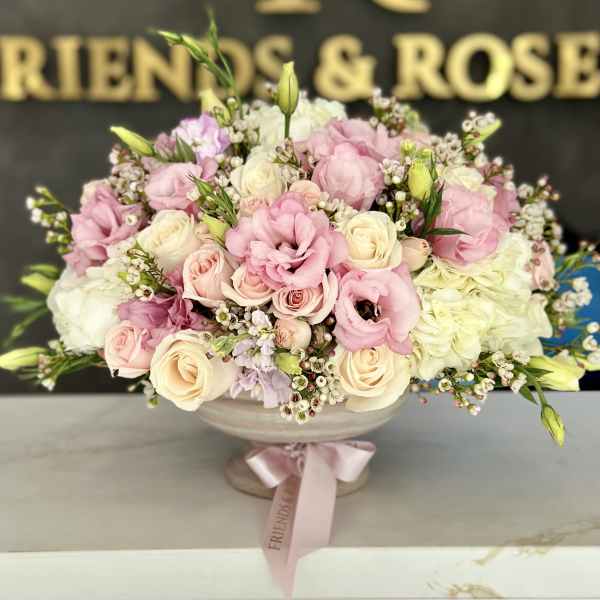 Pink and cream roses with lisianthus in a low glass bowl