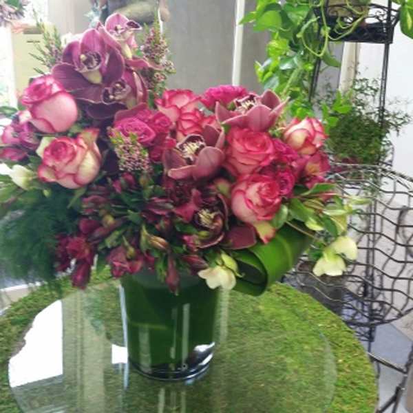 Pink and purple floral arrangement in a green vase