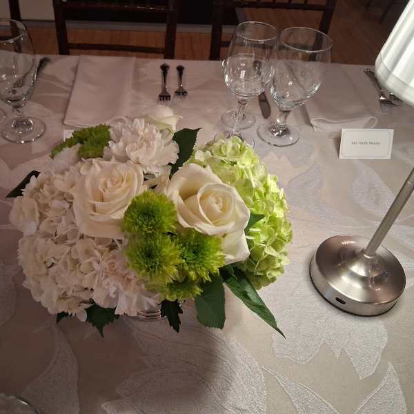 White and green floral centerpiece on a banquet table
