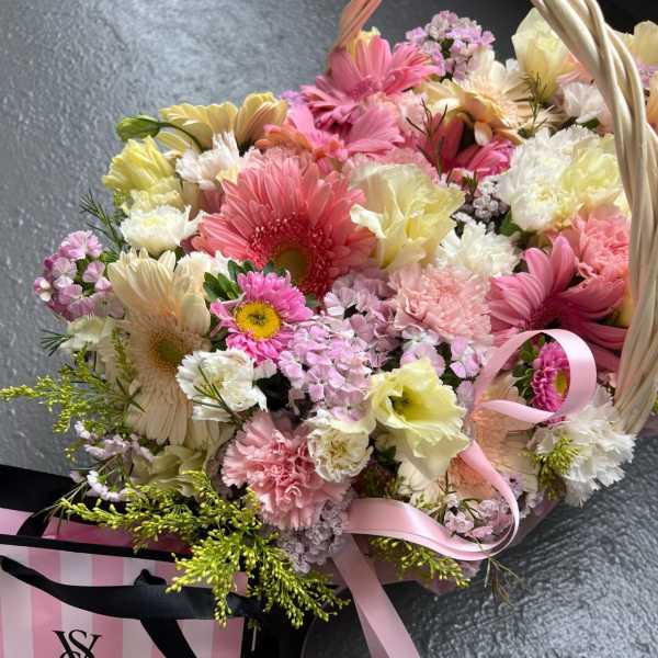Basket bouquet of pink, white, and yellow mixed flowers with ribbon