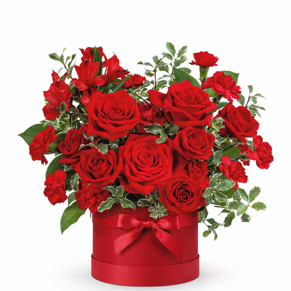 Red roses and carnations in a red hat box with a ribbon