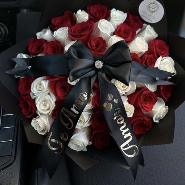 Bouquet of red and white roses wrapped with a black ribbon