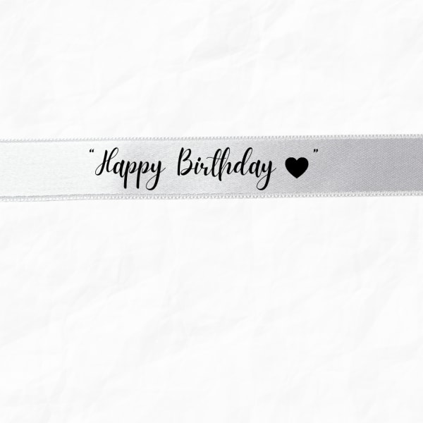 White ribbon with "Happy Birthday" text and a black heart