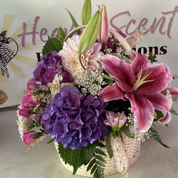 Basket arrangement with pink lilies, purple hydrangeas, and mixed blooms