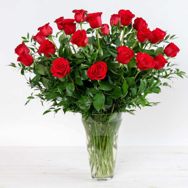 Red roses arranged in a clear glass vase
