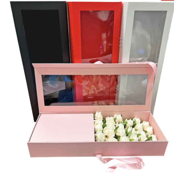 Pink gift box with white roses and three tall window boxes behind it