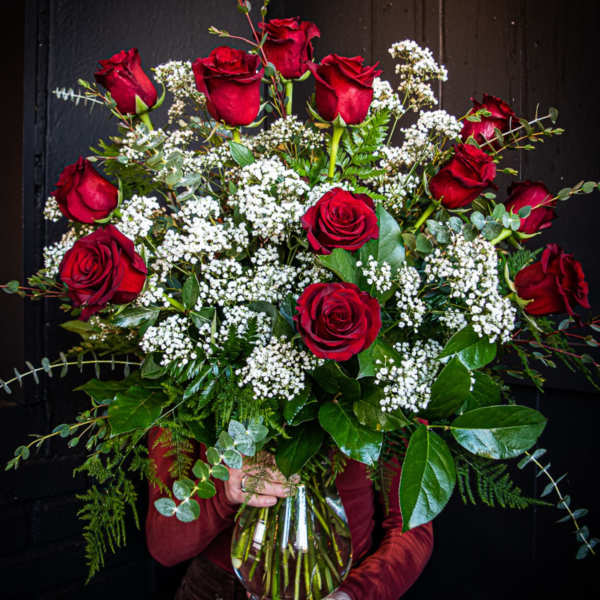 Bouquet of red roses and white filler flowers in a glass vase